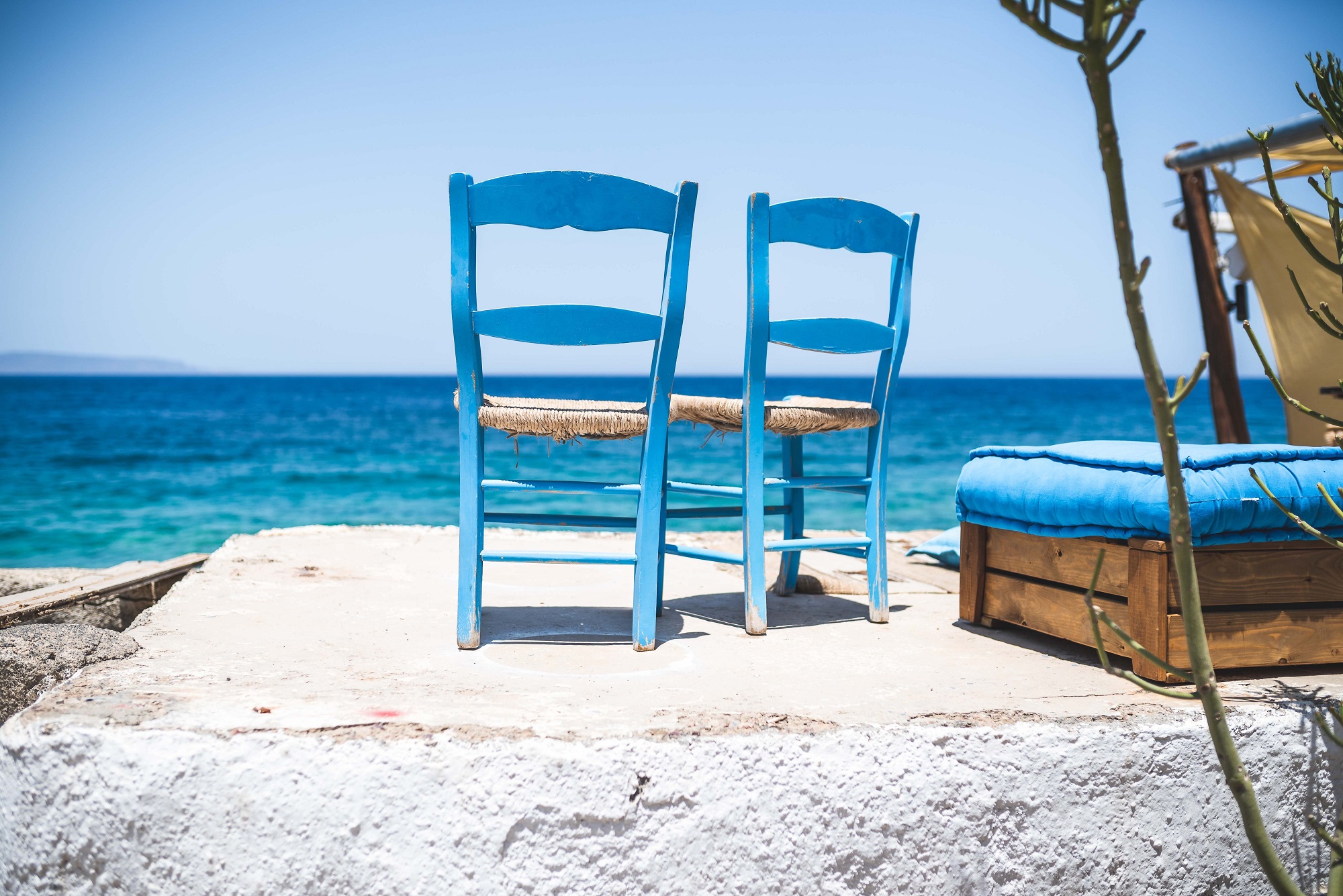 Two chairs sitting by the ocean